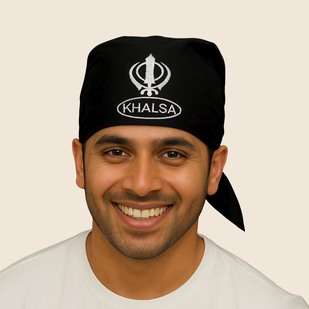 Man wearing a black 'Khalsa' headscarf with a white emblem on a beige background