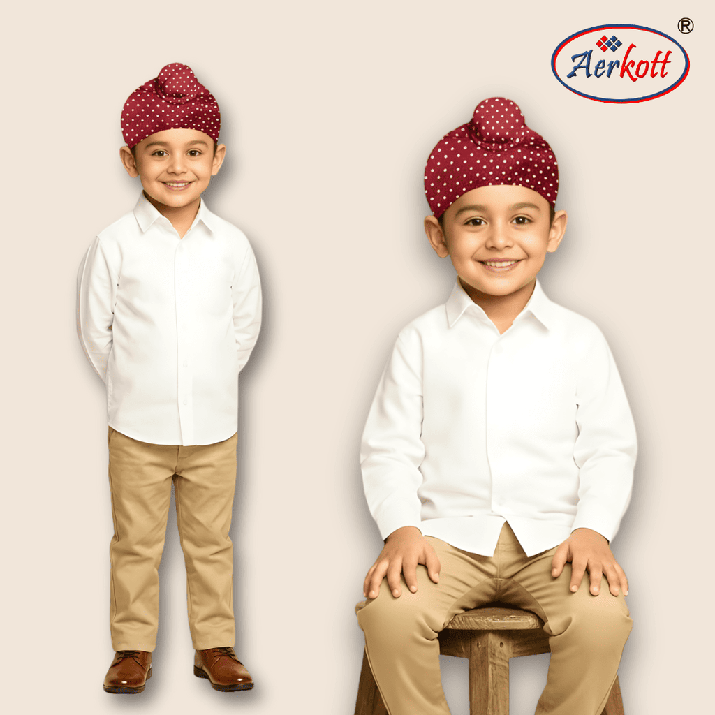 Two children wearing white shirts, beige pants, and red turbans with white patterns on a plain background. Aerkott logo is visible.