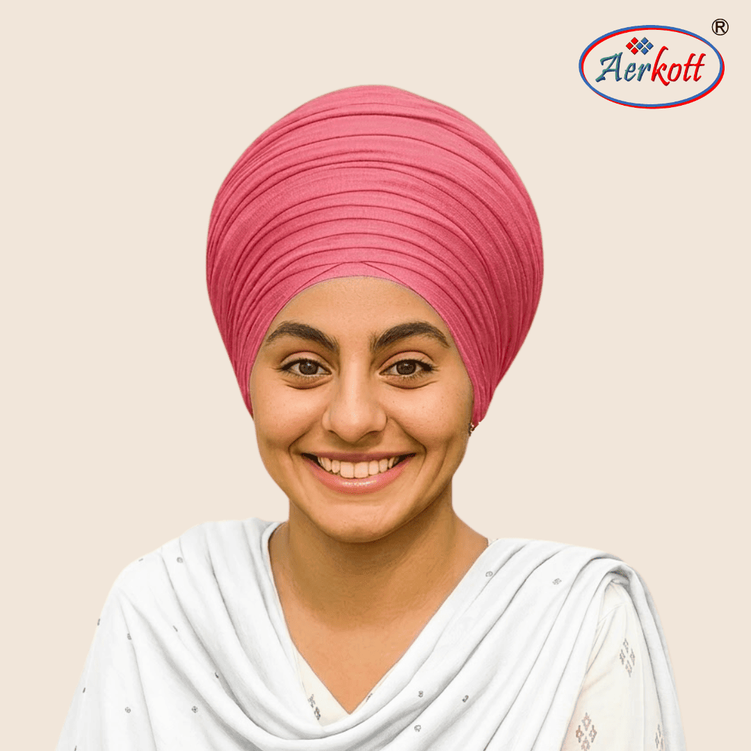 Woman wearing a pink mulmul malmal turban with AERKOTT logo in the corner