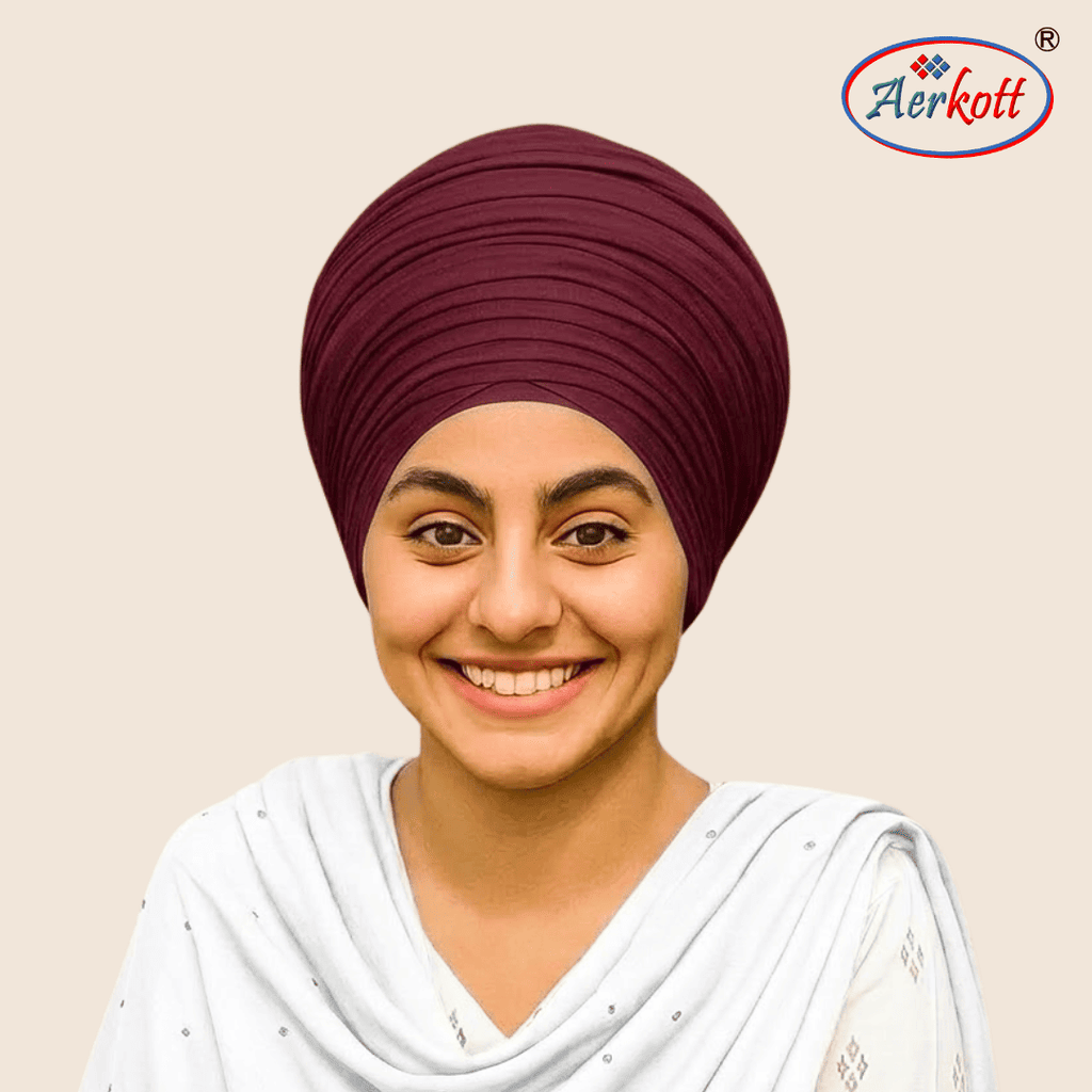 Woman wearing a maroon mulmul malmal turban with AERKOTT logo in the corner