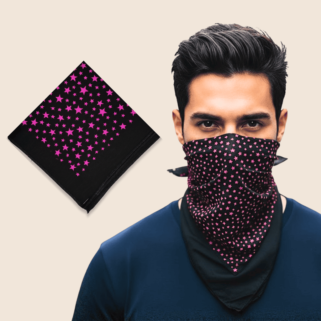 Man wearing a black face mask with pink star pattern next to a matching black fabric square on a beige background