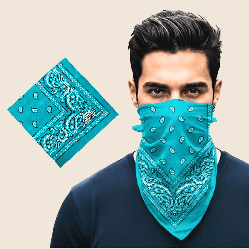 Man wearing a cyan bandana over his face with a matching bandana on a beige background