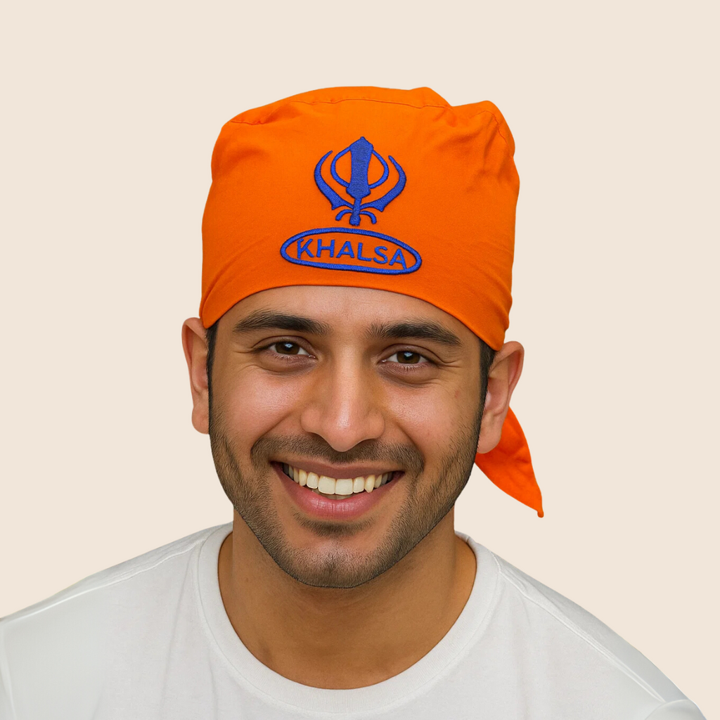 Man wearing an orange 'Khalsa' headscarf on a beige background