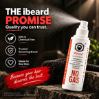 A bottle of ibeard Hair Binding Spray is shown on a dark wooden surface with a mist of spray flying out. The background is dark and moody, with promotional text on the left side highlighting key selling points like 'Safe & Chemical Free' and 'Trusted Grooming Brand'.