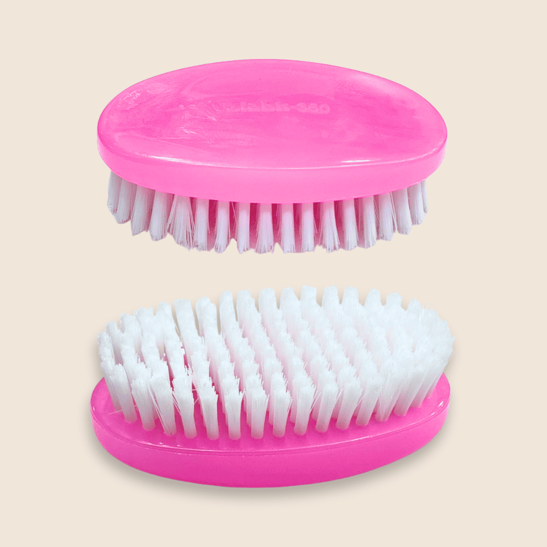 Two pink beard brushes with white bristles on a beige background